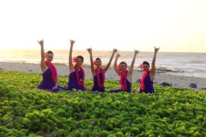 five hula girls seating on beach in hawaii