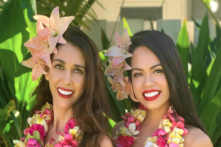 two beautiful hula dancers wearing lei