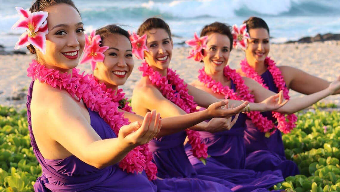 hawaiian ladies on beach in purple pink outfits