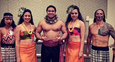 female and male polynesian dancers in costumes