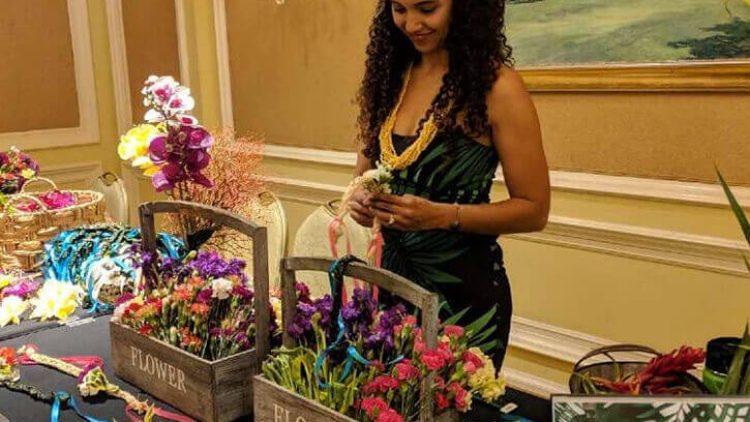 hawaiian woman preparing flowers for lei making